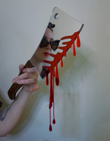 Ambush Blood Test
2025
14" long. The blade is 7.5" long and 5" wide. Including the blood drips – both beaded and acrylic – the height of the piece hanging at the right angle is 13.5"
Acrylic mirror, walnut, brass, thread, beads, paint, pine Ambush Blood Test